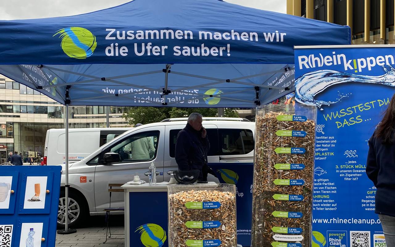 Drei volle durchsichtige Behälter mit Zigarettenkippen