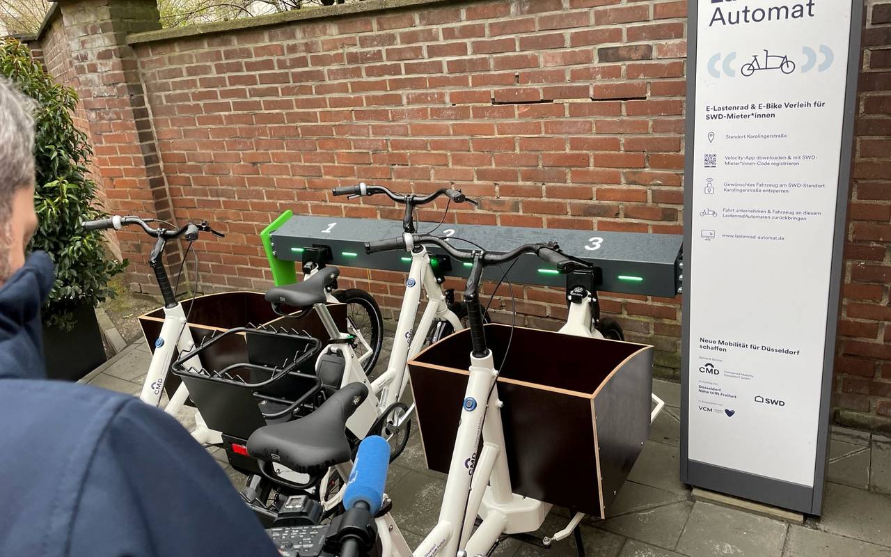 Ein Mann steht vor einem Lastenrad-Automaten. 