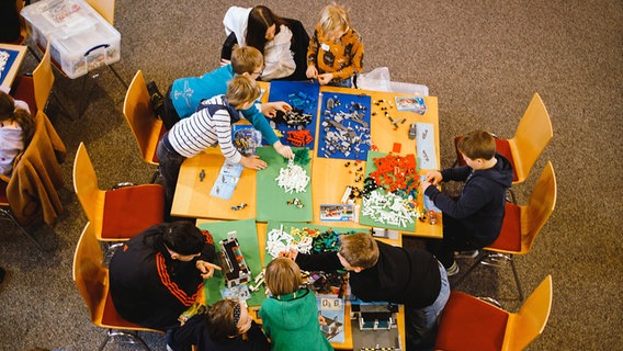 Eine Gruppe von kleinen Kindern sitzt an einem Tisch mit Legosteinen in einem Raum. © Hartmuth Wahnung Foto: Hartmuth Wahnung