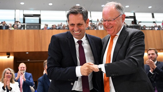 Olaf Lies (SPD, l) wird nach seiner Wahl zum Ministerpräsidenten von Niedersachsen von Stephan Weil (SPD), scheidender Ministerpräsident von Niedersachsen, während der Sitzung des Niedersächsischen Landtags beglückwünscht. © dpa Bildfunk Foto: Julian Stratenschulte