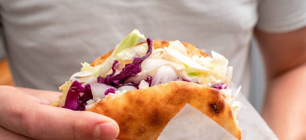 Mann hält einen Döner (Symbolfoto): In der Dresdner Neustadt gibt es am Donnerstag ein besonderes Angebot.