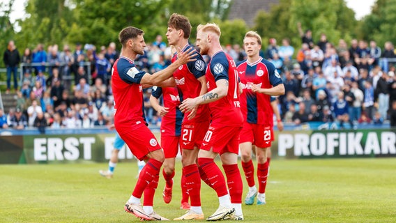 Rostocks Nils Fröling (2.v.r.) und seine Mitspieler bejubeln einen Treffer. © IMAGO / Andy Bünning 
