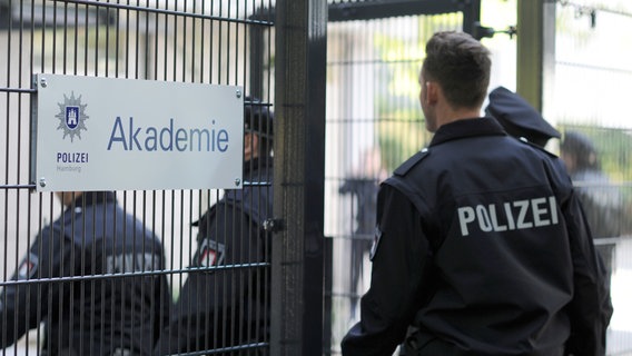 Polizisten gehen am Hamburg durch das Eingangstor der Polizeiakademie. © picture alliance / dpa Foto: Angelika Warmuth
