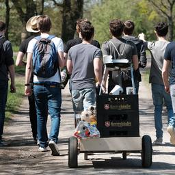 Eine Gruppe junger Männer feiert den Vatertag mit einem mit Bier gefüllten Bollerwagen. (Quelle: dpa/Peter Steffen)