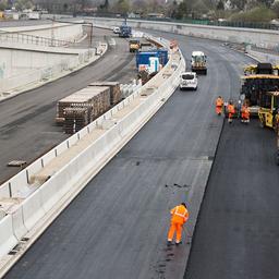Archivbild: Auf der Baustelle der A100 wird eine Fahrbahn mit einer Schicht Asphalt gewalzt. (Quelle: dpa/J. Carstensen)