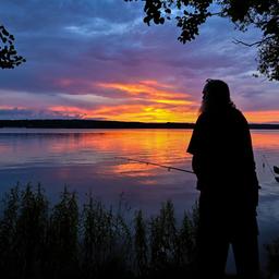 Ein Mann und ein Kind stehen an einem Brandenburger See und angeln. Quelle: dpa/Patrick Pleul