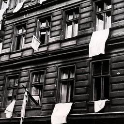 Aus den Fenstern unzerstörter Wohnhäuser in einer Straße in Berlin hängen als Zeichen der Kapitulation weiße Tücher, aufgenommen Ende April 1945. (Quelle: dpa-Zentralbild/Jewgeni Chaldej)