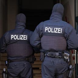 Archivbild:  Polizisten stehen während einer Razzia gegen mutmaßliche Rechtsextreme in einem Hauseingang. (Quelle: dpa/Kahnert)