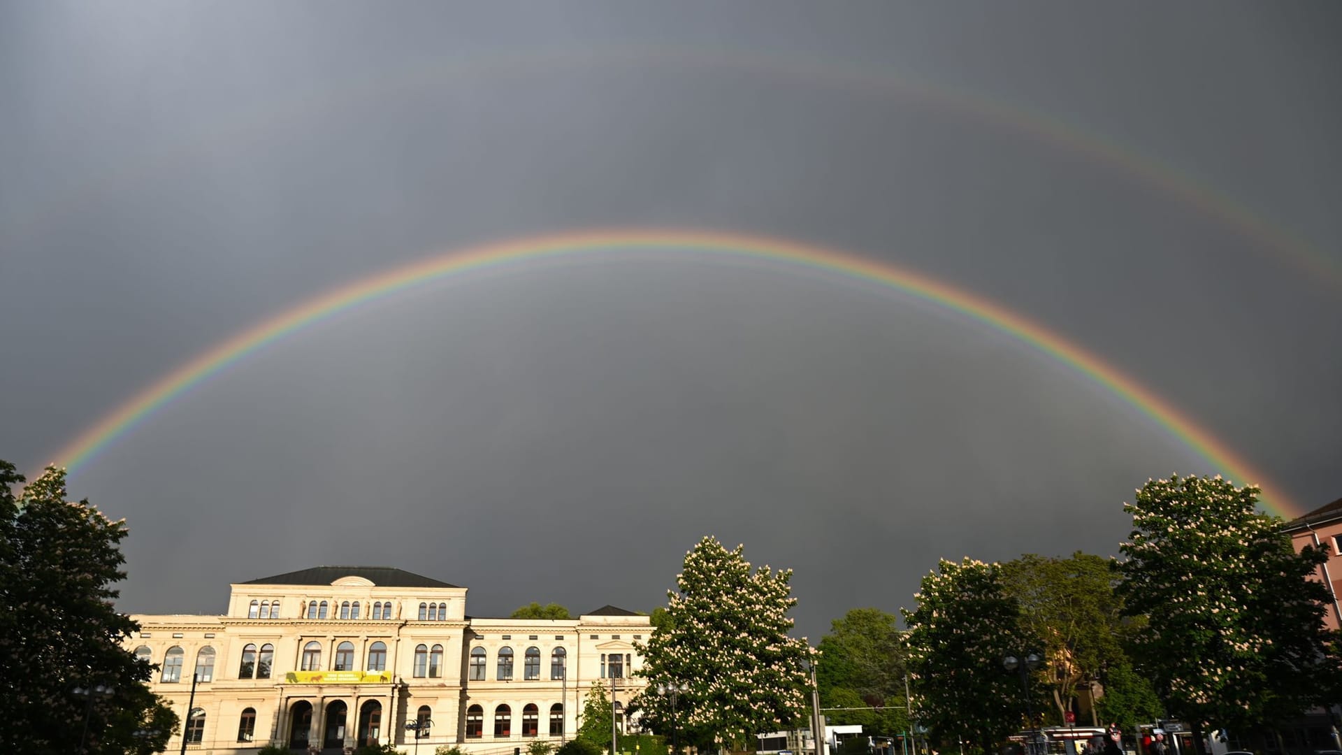 Nach einem Regenschauer ist am Himmel über dem Frankfurter Zoo-Gesellschaftshaus ein Doppelregenbogen zu sehen