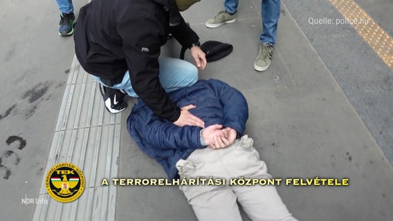 Ein Mann liegt mit Handschellen am Boden, eine weiter Person kniet auf ihm. © Screenshot 