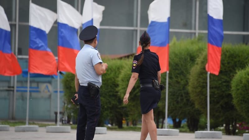 Sicherheitskräfte am Flughafen von Wolgograd (Russland) vor russischen Flaggen.