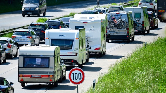 Zahlreiche Wohnmobile, Wohnwagen und Autos stehen im Autobahn-Stau. © dpa Foto: Jonas Walzberg