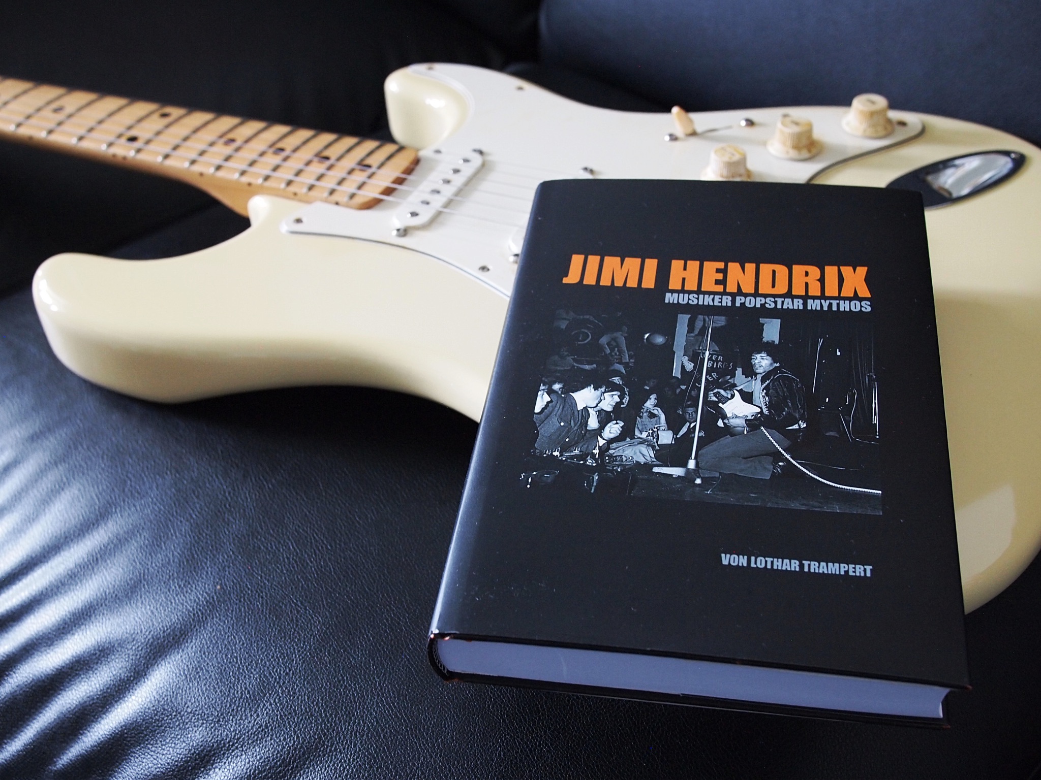 Buch Jimi Hendrix Musiker Popstar Mythos Hardcover auf cremefarbener Fender Stratocaster