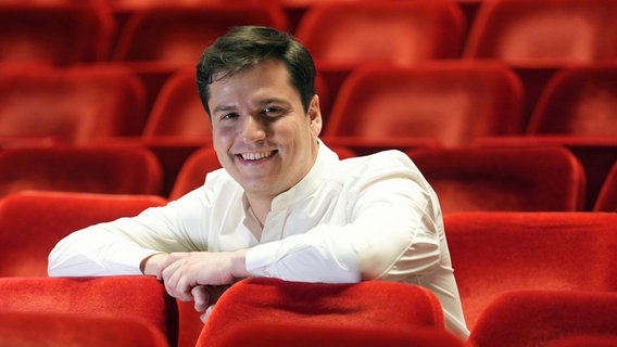 Demis Volpi, neuer Intendant des Hamburg Balletts, sitzt nach einer Pressekonferenz im Zuschauersaal der Staatsoper. © dpa Foto: Marcus Brandt