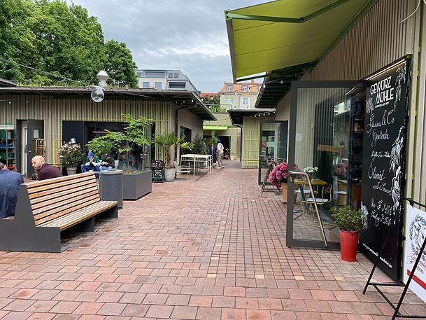 Der Schwabinger Elisabethmarkt mit seinen Neubau-Standln ist seit Herbst 2024 geöffnet. Hier ein Blick in einen der Innenhöfe mit Sitzgelegenheiten.