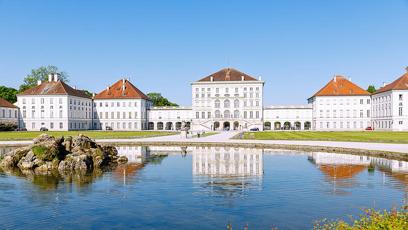 Schloss Nymphenburg mit Schlossgartenkanal im Morgenlicht.