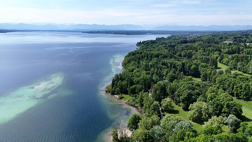 Blick von oben auf den Feldafinger Park, links der Starnberger See, am Horizont die Alpenkette im Dunst.