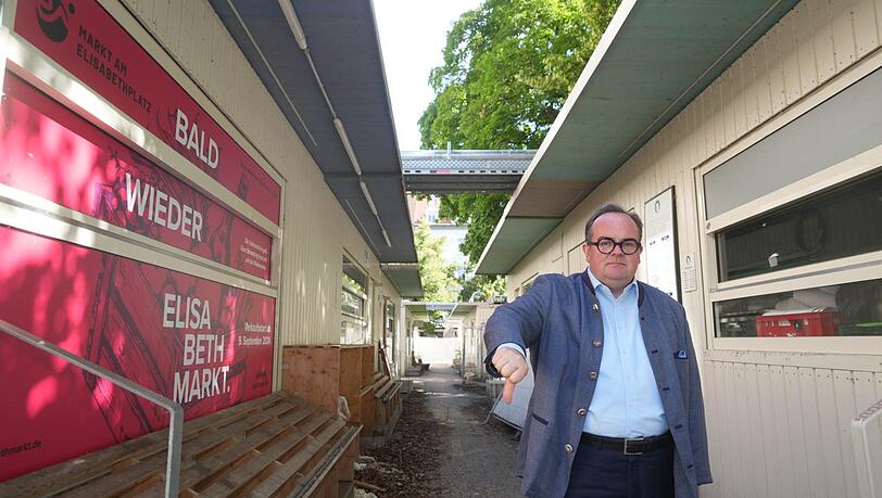 Hier steht OB-Kandidat Clemens Baumgärtner (CSU) auf der Sackgasse am Elisabethmarkt, um die es geht. Die weißen Interimscontainer der Markthändler werden nicht mehr gebraucht, stehen aber noch immer auf dem Nordstück der Arcisstraße.