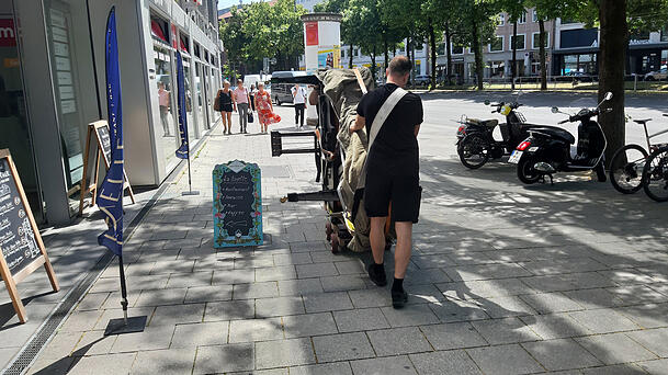 Bei Temperaturen um die 30 Grad werden die kostbaren Flügel über die Herzog-Wilhelm-Straße ins neue Domizil in der Sonnenstraße 19 gerollt.