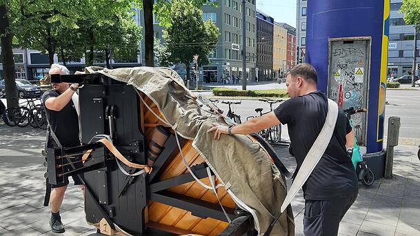 Ganz vorsichtig transportieren die beiden Umzugsprofis den rund 300 Kilogramm schweren Flügel durch die Sonnenstraße.