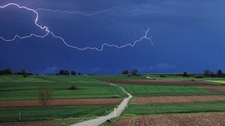 Ein Blitzt zuckt aus einer Gewitterzelle. In Baden-Württemberg werden schwere Gewitter erwartet, große Hagelkörner können viele Schäden verursachen.