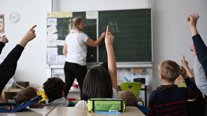 Symbolbild: Lehrerin an der Tafel - Schüler einer Grundschule arbeiten in einem Klassenzimmer an Mathematikaufgaben. (Quelle: dpa/Weißbrod)