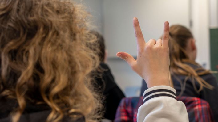 Eine Schülerin zeigt im Unterricht für Gebärdensprache das Zeichen für "I love you". (Quelle: dpa/Evelyn Denich)