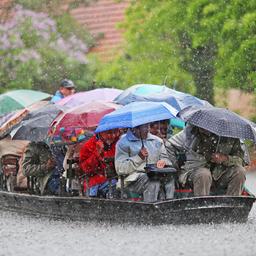 Symbolbild:Auf einem Spreewald-Kahn schippern Ausflügler unter Regenschirmen im strömenden Regen über die Hauptspree bei Lübbenau.(Quelle:picture alliance/dpa/K.Nietfeld)