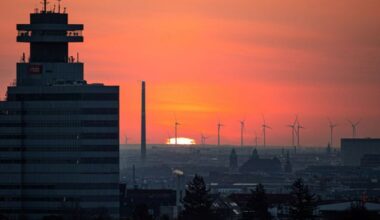 Archivbild: Die aufgehende Sonne über Berlin mit Windrädern im Hintergrund. (Quelle: dpa/Keuenhof)