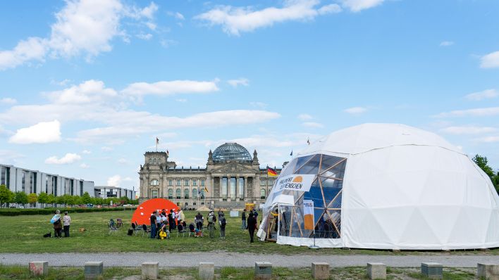 Klimaschutzgruppe Neue Generation haben zum Auftakt einer Protest- und Widerstandswoche auf der Wiese vor dem Reichstagsgebäude ein weißes Zelt für das "Parlament der Menschen" aufgestellt. (Quelle: dpa/Soeren Stache)