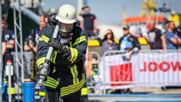 Symbolbild: Feuerwehrmann Ryan Green sprintet bei der Firefighter Combat Challenge in Bremerhaven mit einem Schlauch zum Brandort (Quelle: dpa/Focke Strangmann)