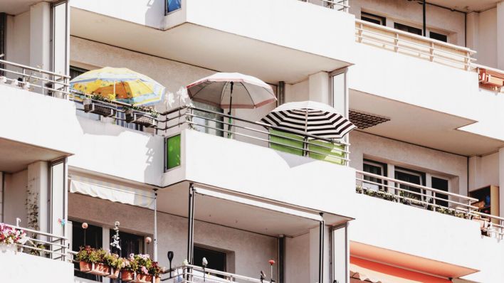 Symbolbild: Sonnenschirme auf dem Balkon eines Plattenbaus, aufgenommen in Berlin. (Quelle: dpa/Gaertner)