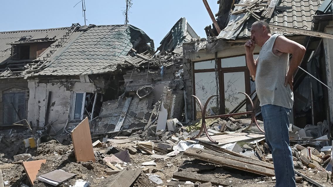 Nach einem russischen Angriff auf die Stadt Saporischschja steht ein Mann in den Trümmern eines Hauses.