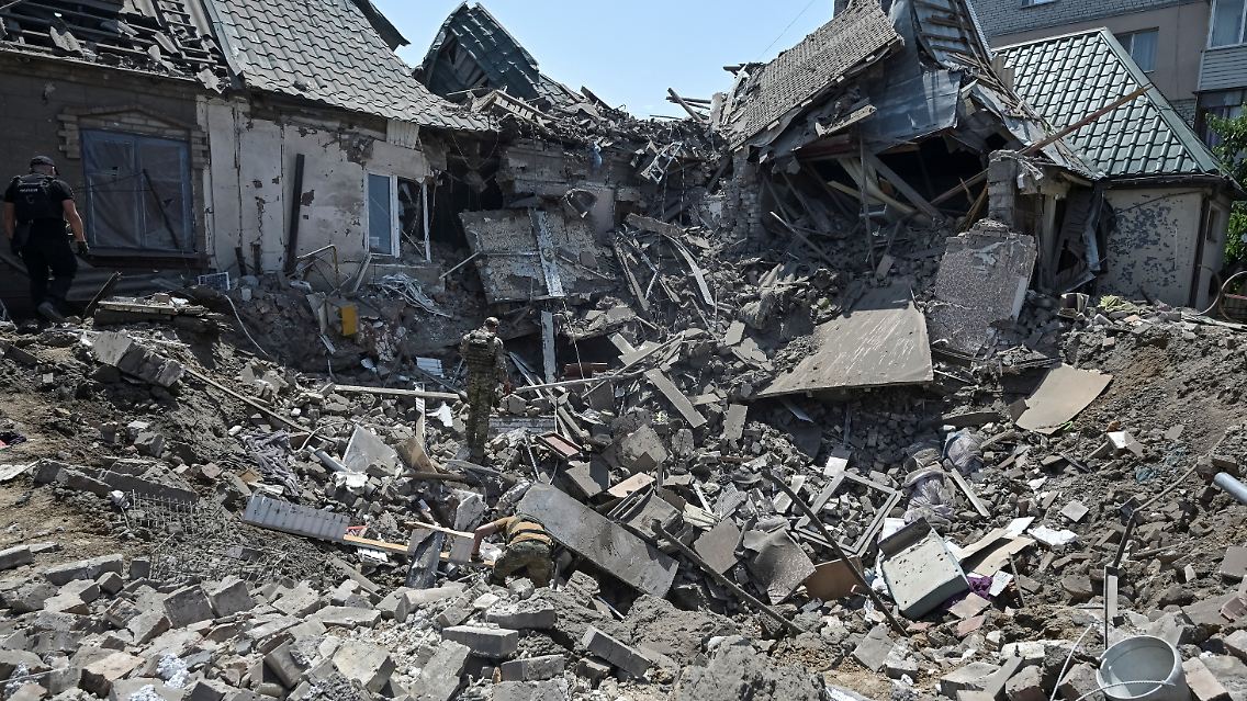 Nach einem russischen Angriff suchen Experten unter einem eingestürzten Gebäude in Saporischschja nach Überlebenden.