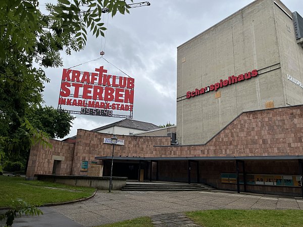 Der Schriftzug "Kraftklub: Sterben in Karl-Marx-Stadt" hing Ende Mai an einem Kran am Chemnitzer Schauspielhaus. - © picture alliance/dpa/dpa-Zentralbild