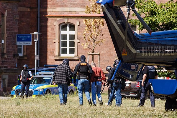 Der mutmaßliche Täter von Bielefeld, Mahmoud M., trifft in Karlsruhe ein und wird von Polizeibeamten von einem Helikopter zu einem Fahrzeug geführt. - © Philipp von Ditfurth/dpa