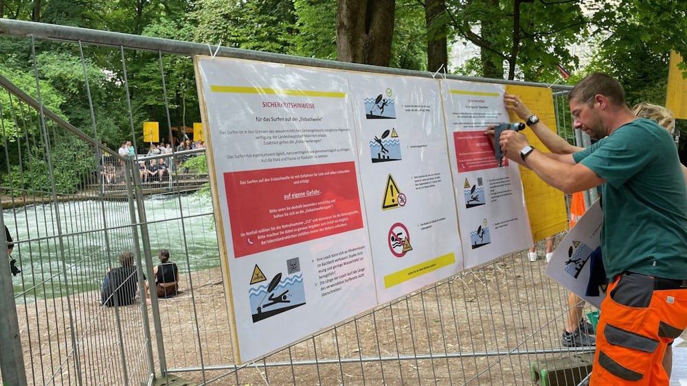 Mitarbeiter der Stadt bringen Schilder mit den neuen Regeln an.