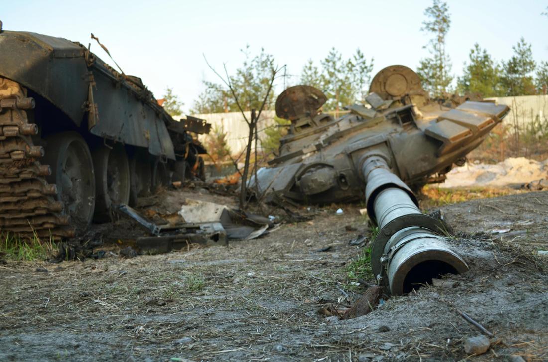 Panzerturm auf dem Boden neben zerstörtem Panzerchassis der russischen Armee nach Gegenangriffen der ukrainischen Streitkräfte.