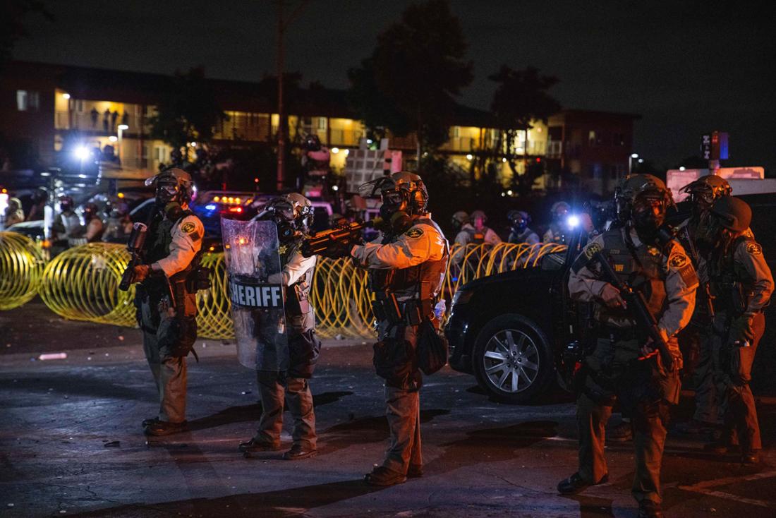 Los Angeles County Sheriffs stehen während eines Protestes nachdem die Bundeseinwanderungsbehörden Operationen durchgeführt haben. Demonstranten protestierten gegen die Operation der Bundeseinwanderungsbehörde vom Vortag, bei der die Behörden Dutzende von Menschen festgenommen hatten.