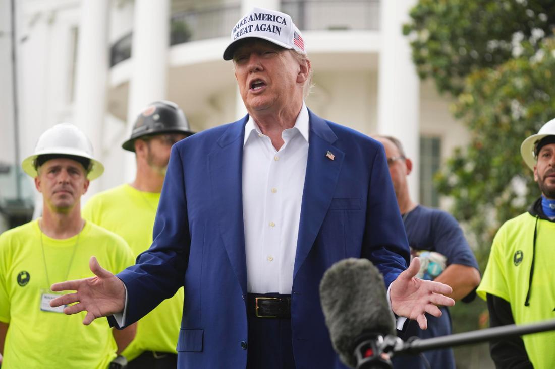 US-Präsident Donald Trump spricht zu Arbeitern, während ein Flaggenmast auf dem Südrasen des Weißen Hauses installiert wird.