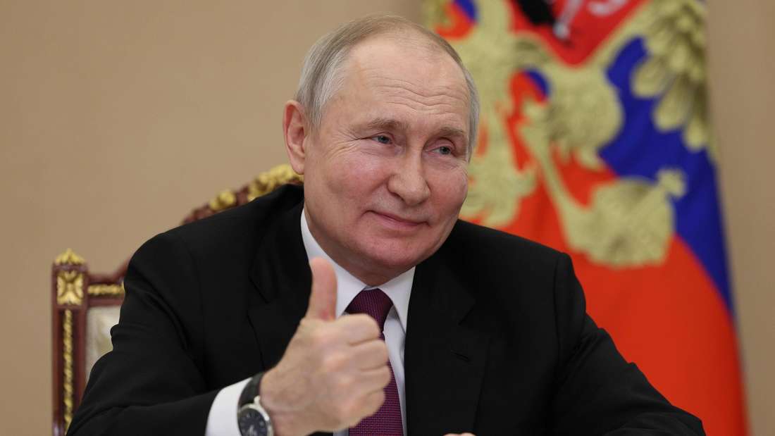 Wladimir Putin lächelt und zeigt mit dem Daumen noch oben.