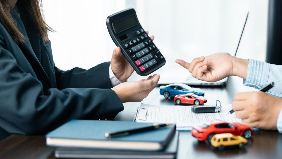 Verkaufsleiter bietet an, ein Auto zu verkaufen und erklärt und liest die Bedingungen für die Unterzeichnung eines Autokredits vor.
