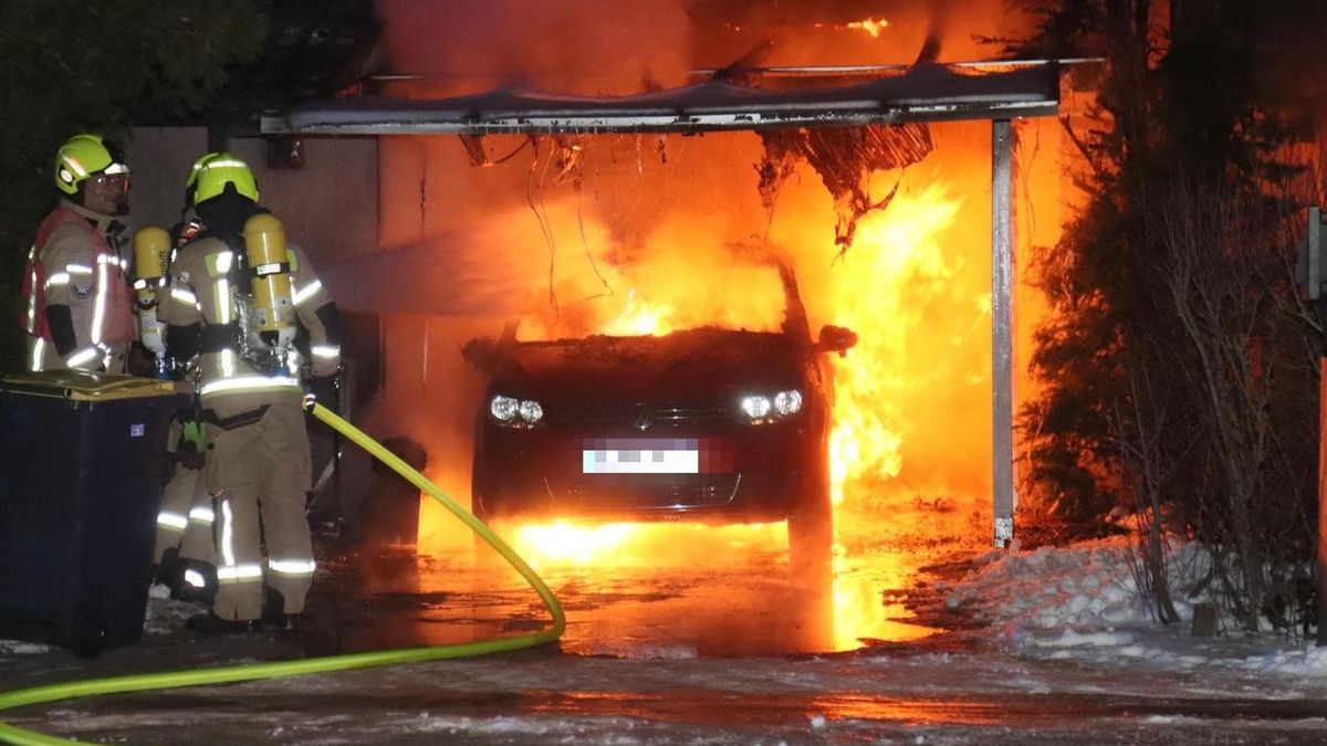 Die Feuerwehr löscht das brennende Auto.