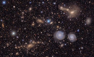 Die Aufnahme zeigt einen kleinen Ausschnitt des Virgo-Galaxienhaufens. Zu sehen sind unter anderem zwei auffällige Spiralgalaxien (unten rechts), drei verschmelzende Galaxien (oben rechts), mehrere Gruppen ferner Galaxien und zahlreiche Sterne in der Milchstraße. 