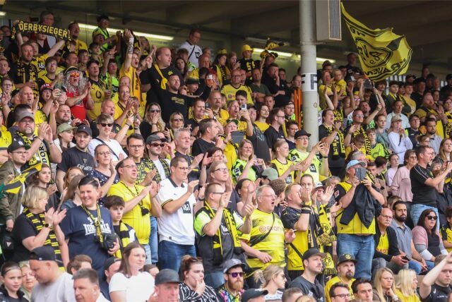 Fans auf der Tribüne in der Roten Erde
