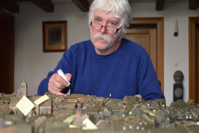 Egbert Broerken sitzt hinter einem Bronzemodell einer unbekannten Stadt.