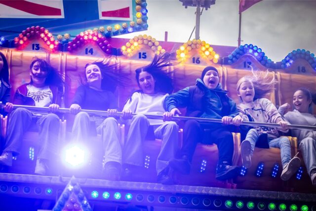Jugendliche auf dem Scheibenwischer-Fahrgeschäft „Jump Street“