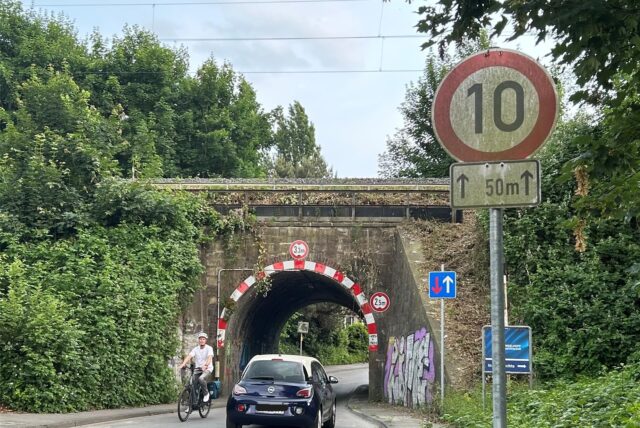 Ein Radfahrer und ein Auto begegnen sich an der engen Tunneldurchfahrt am Zehnthof.