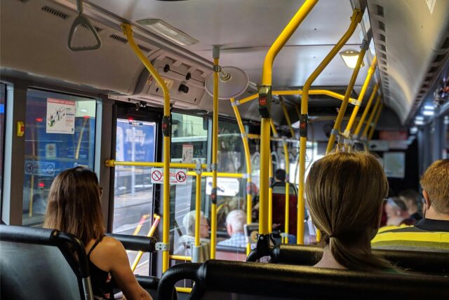 Ein Linienbus mit zahlreichen Menschen von hinten.