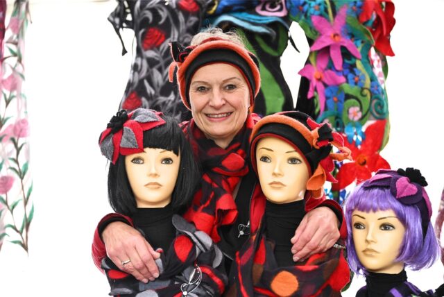 Eine Frau und drei Mannequin-Puppen beim Hertener Kunstmarkt 2025.